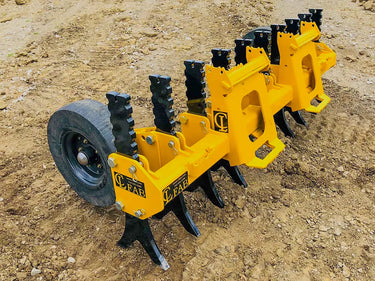 A yellow tracked skid steer loader with black rubber tracks and a yellow plow attachment parked on a dirt construction site.